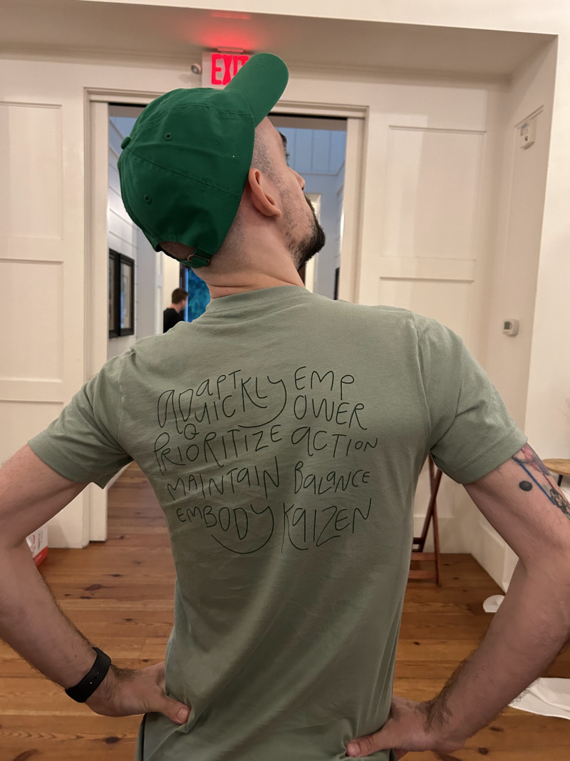 A Chameleon team member at a company offsite, seen from behind in a t-shirt displaying company values.
