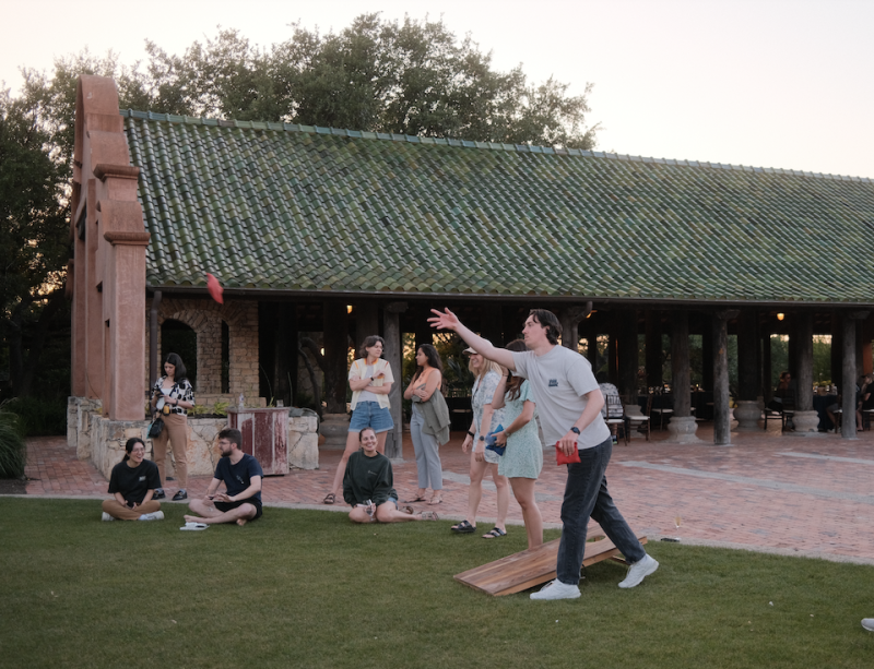 Chameleon team members playing cornhole at an outdoor team offsite.